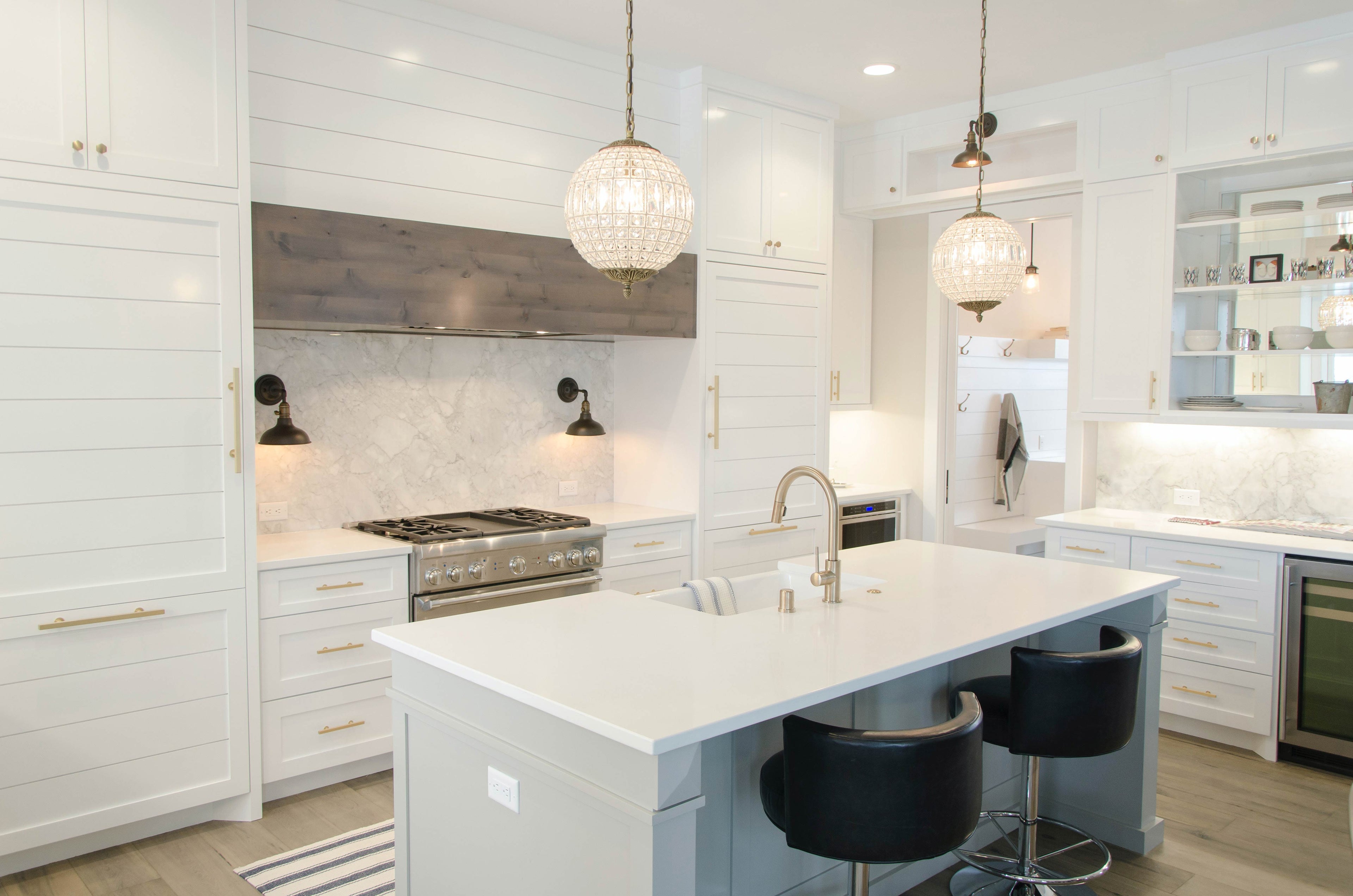 modern kitchen with white cabinets and countertops and polished brass handles